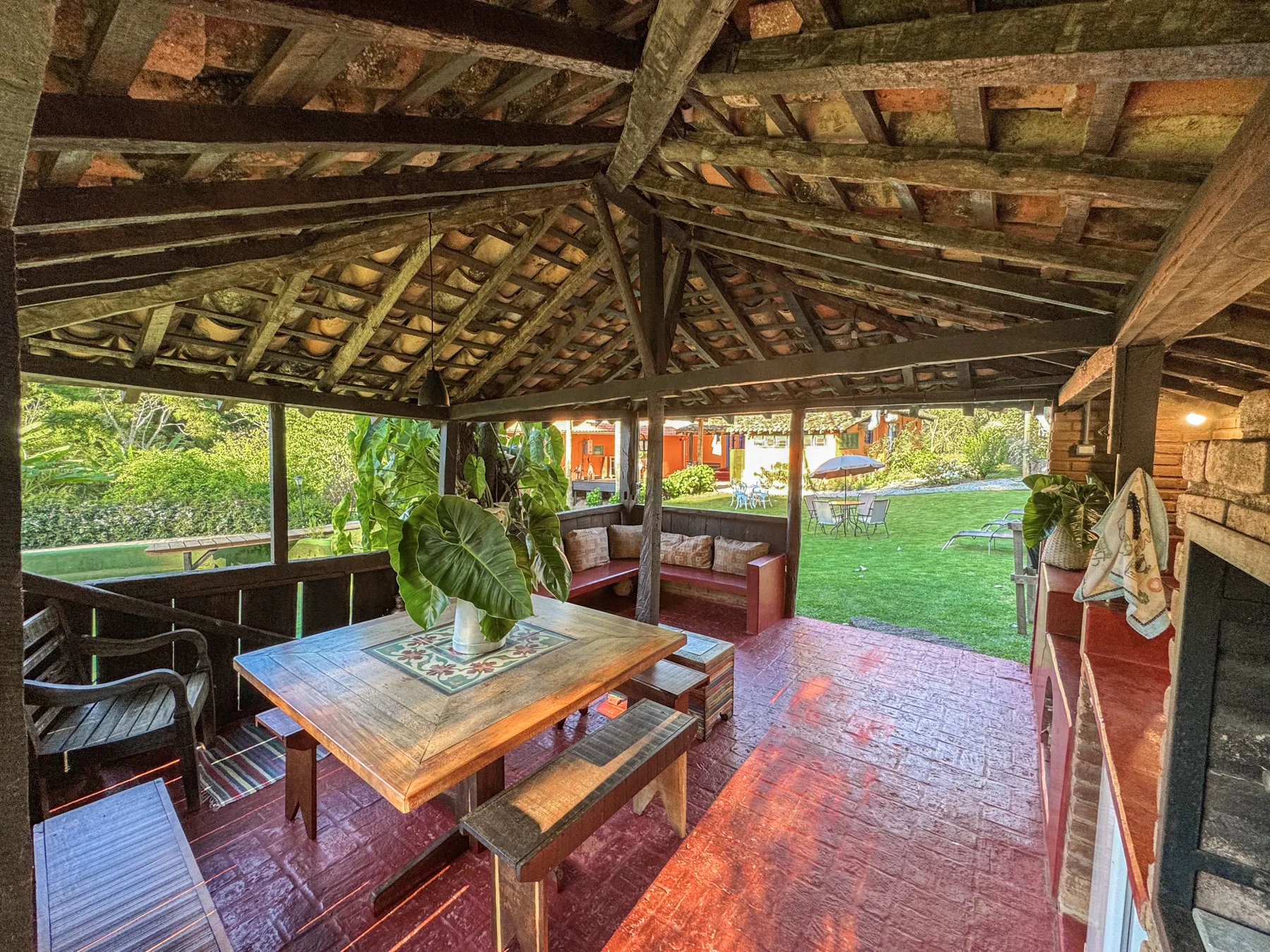 Mesa de madeira na varanda coberta, com vista para o jardim