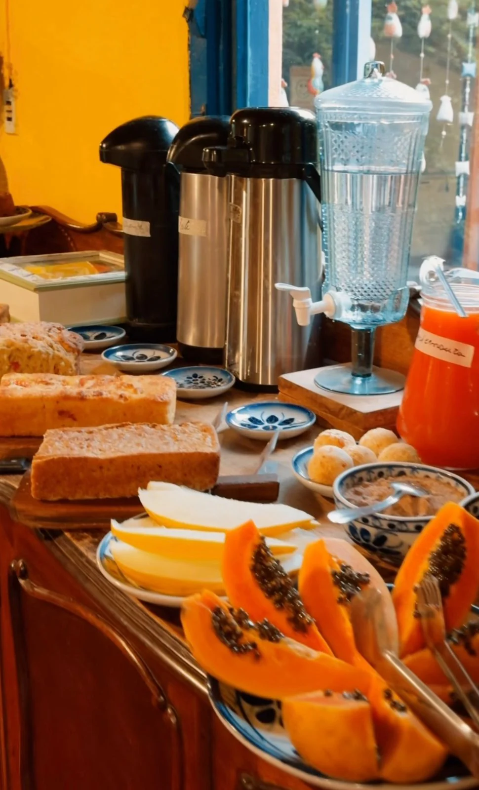 Frutas, bolos, pão de queijo e bebidas no café da manhã