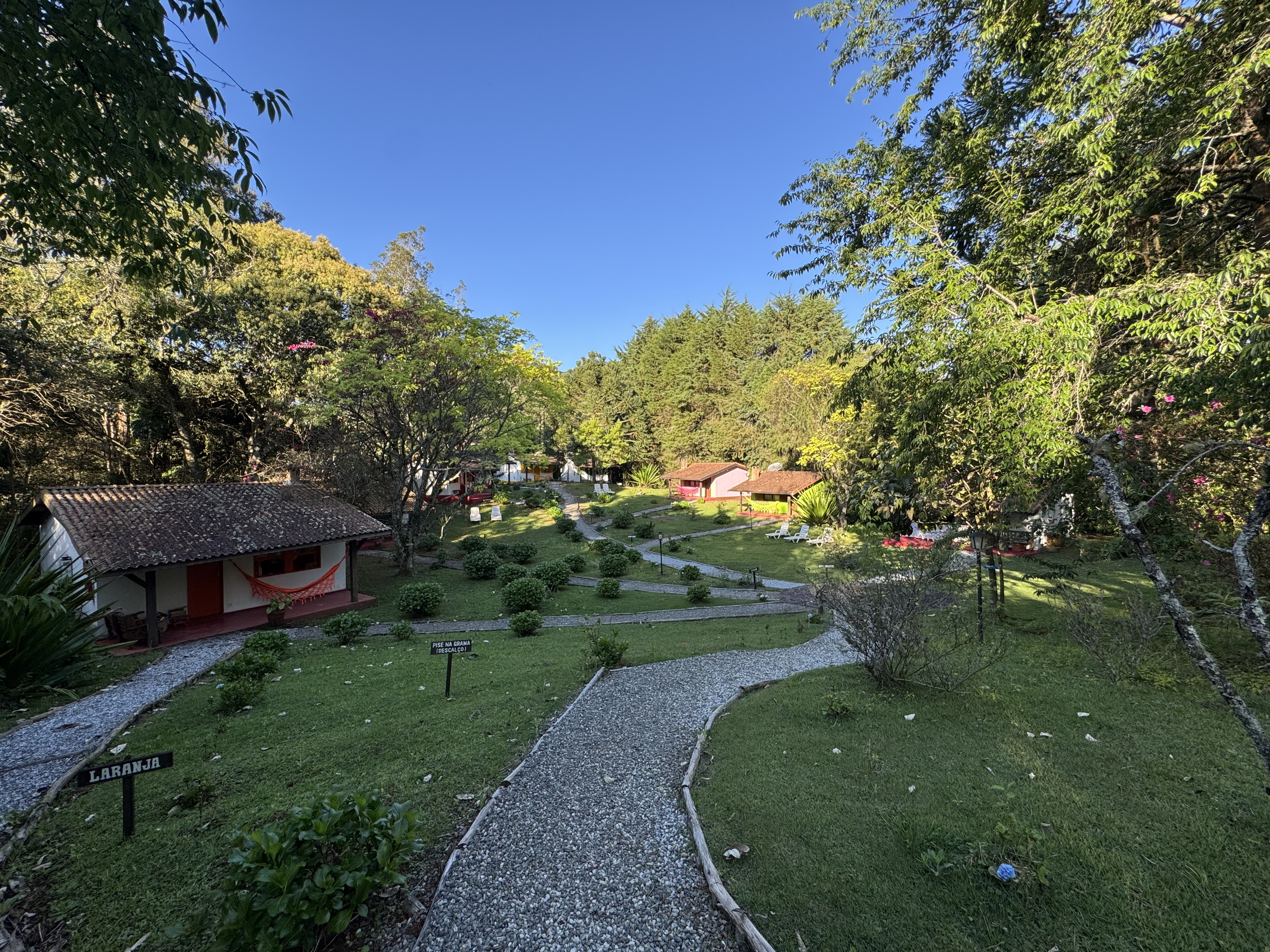 Vila de casinhas coloridas e jardins da Pousada Trem das Cores sob o céu azul